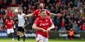 Paul Mullin celebra el primer gol anotado ante Notts County mostrando una 'A' de Albi