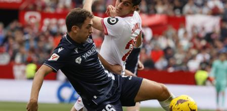 Olasagasti protege el balón ante Juanlu en el Sevilla-Real Sociedad