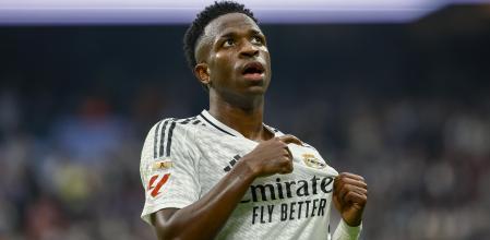 Vinicius se señala el escudo de su camiseta tras marcar uno de sus goles ante Osasuna en el Bernabéu